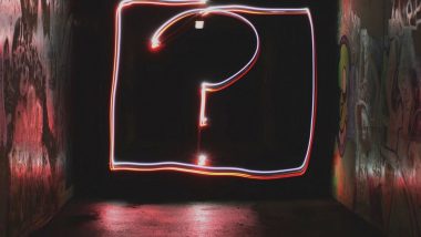 fluorescent pink question mark at the end of a dark hallway